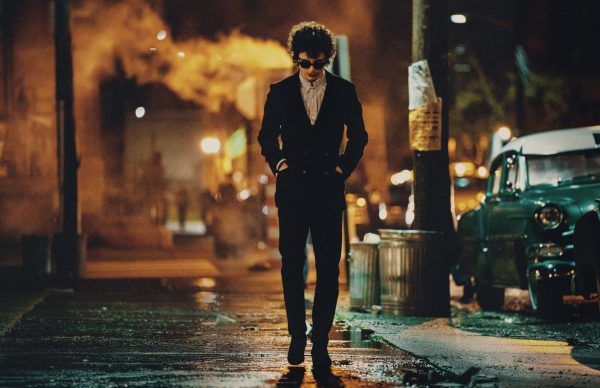 Thimothée Chalamet en Bob Dylan avançant dans la nuit avec des lunettes de soleil dans Un parfait inconnu